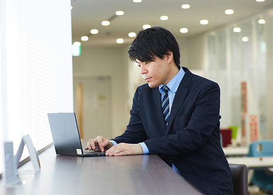 PCに向かって仕事をする永井 遼の写真