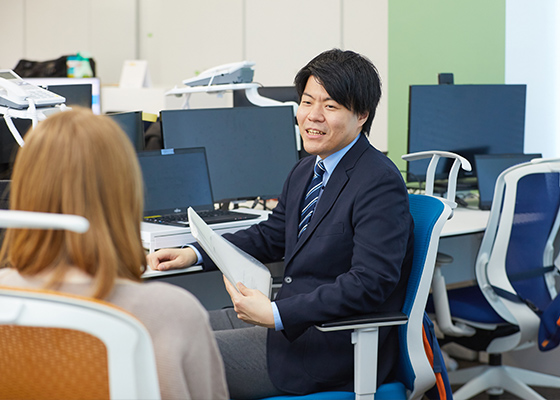 同僚と話している永井 遼の写真