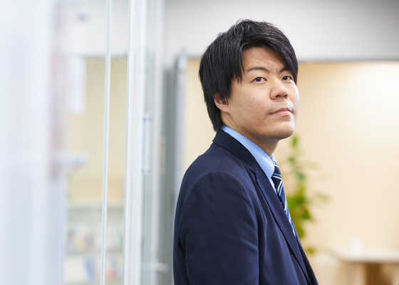 上を見上げる永井 遼の上半身の写真