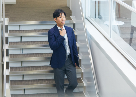 オフィス内を歩く奈良 真史の写真