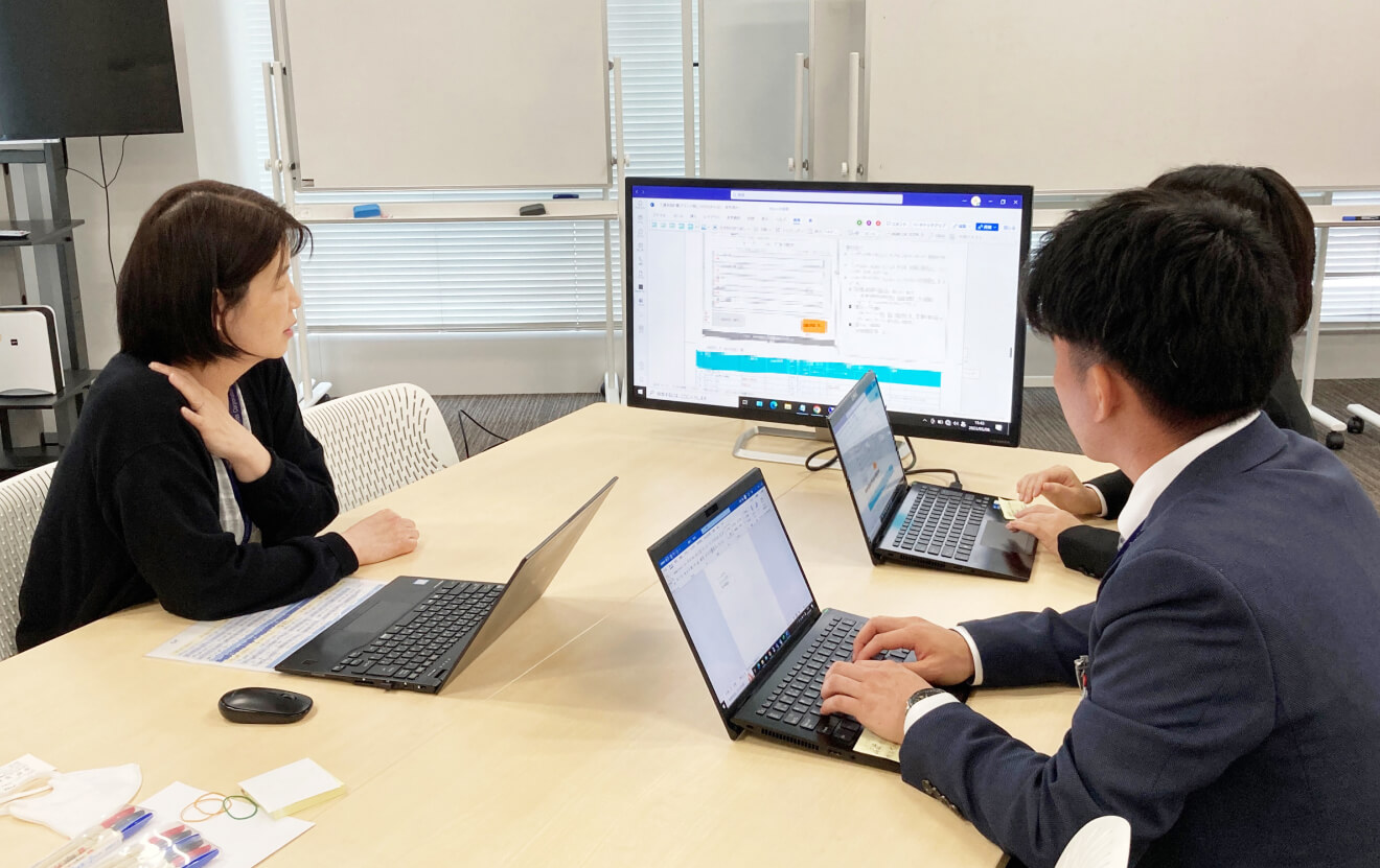 写真:モニターを見ながらミーティングをする社員