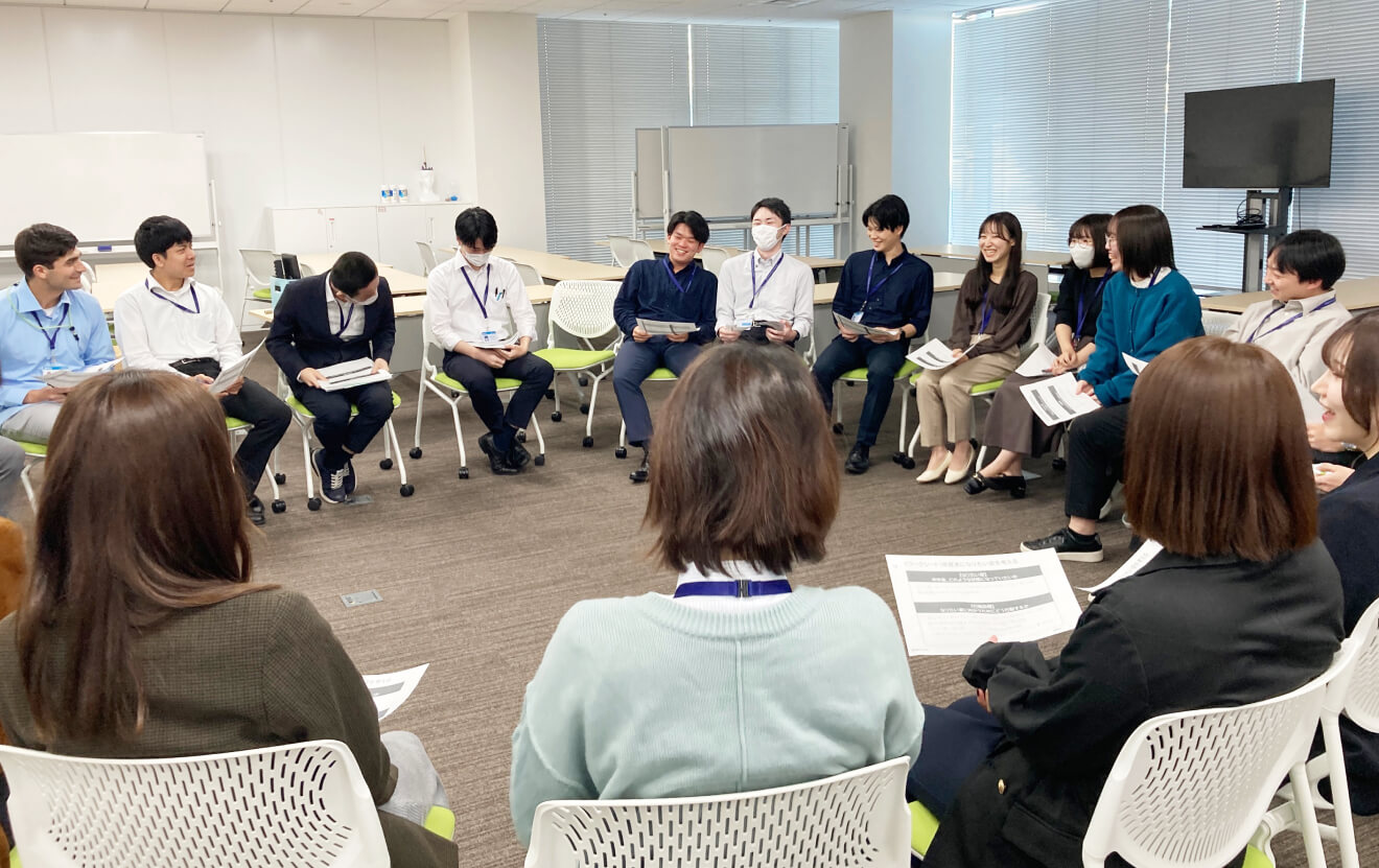 写真:研修風景。新入社員が円になり話をしている。