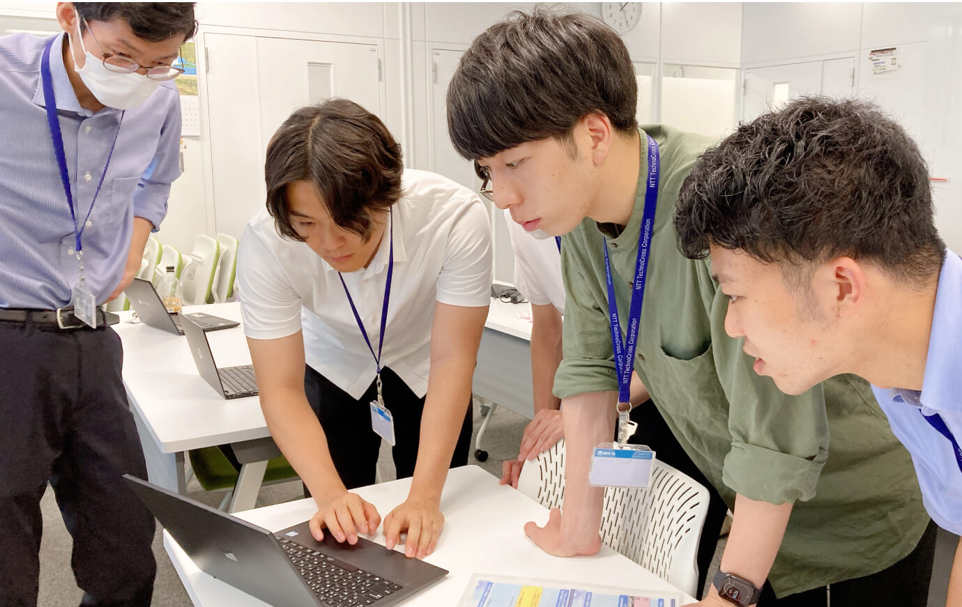 写真:ノートPCを見ながら研修している社員4名